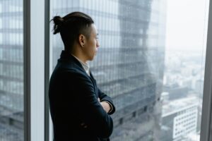 person looking out a window, tense posture, representing need for control in relationships